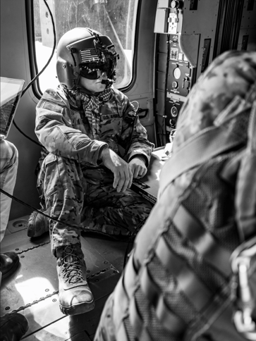 Soldier watching unit perform blood transfusion 